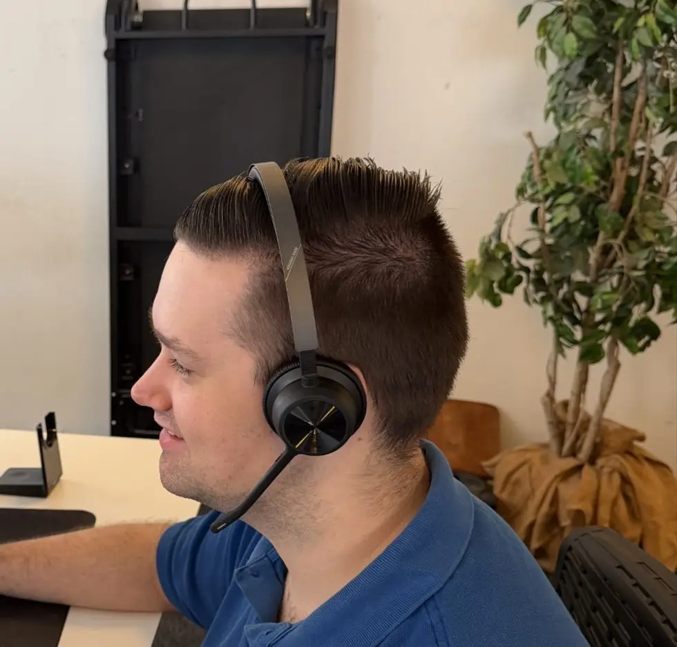 IT-supporter hos A-one Solutions med headset klar ved telefonen